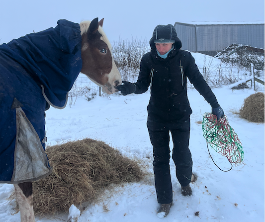 Caring for her horse in the snow is easier when staying warm in the Catago Trainer Winter Jump Suit, says Your Horse's tester Stephanie