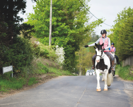 A horse rider signals right as per The Highway Code while riding on the road