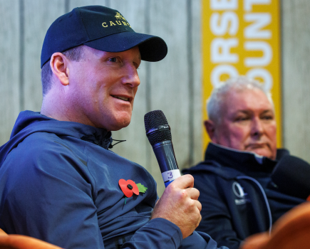 Oliver Townend is pictured talking into a microphone at Your Horse Live in 2023 with Geoff Billington in the background